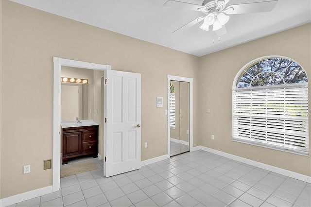 4404 Lake In The Woods Dr, Spring Hill, FL 34607 - unfurnished bedroom featuring a sink, baseboards, light tile patterned floors, and ceiling fan