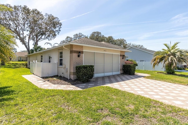 7472 Clearmeadow Dr, Spring Hill, FL 34606 - view of side of property featuring brick siding, an attached garage, fence, a yard, and driveway