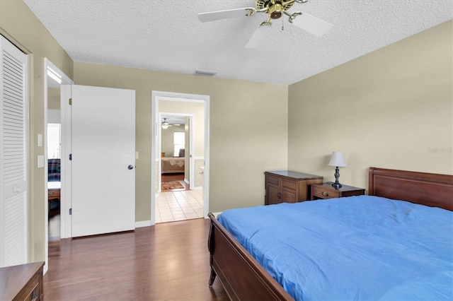7472 Clearmeadow Dr, Spring Hill, FL 34606 - bedroom featuring dark wood-style floors, visible vents, ceiling fan, ensuite bathroom, and a textured ceiling