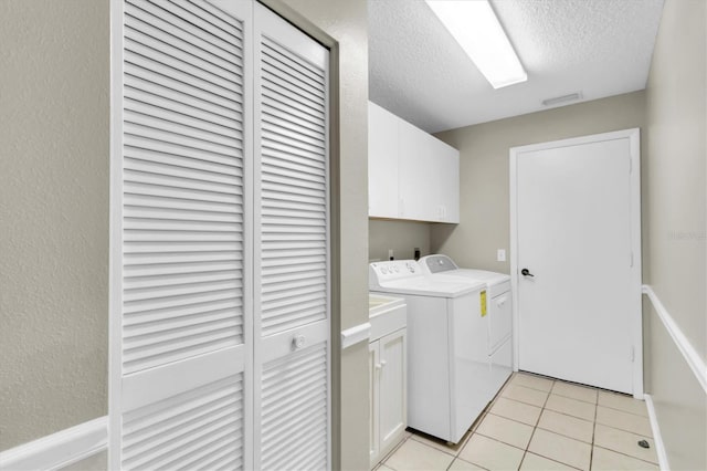 7472 Clearmeadow Dr, Spring Hill, FL 34606 - laundry area featuring light tile patterned floors, a textured wall, cabinet space, a textured ceiling, and independent washer and dryer