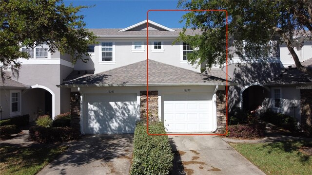 view of front of house featuring a garage, driveway, roof with shingles, and stucco siding