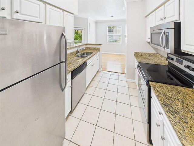 1810 E Palm Ave Unit 6104, Tampa, FL 33605 - kitchen featuring appliances with stainless steel finishes, a sink, ornamental molding, white cabinets, and stone countertops