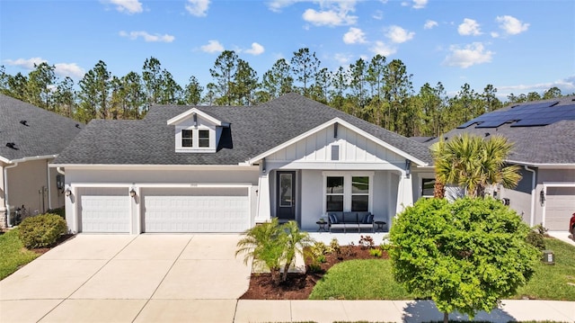 view of front facade featuring a porch, concrete driveway, an attached garage, a shingled roof, and board and batten siding