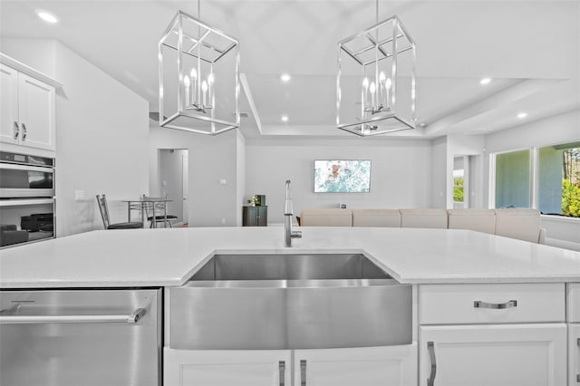 kitchen featuring a sink, light countertops, stainless steel appliances, a raised ceiling, and recessed lighting