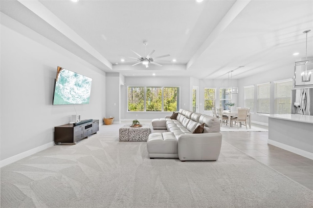 living room featuring recessed lighting, a ceiling fan, baseboards, and a tray ceiling