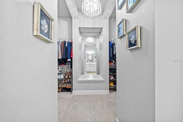spacious closet featuring a notable chandelier