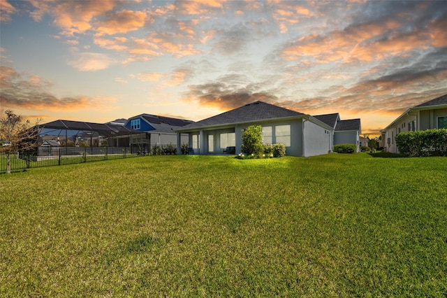 exterior space with stucco siding, fence, and a yard