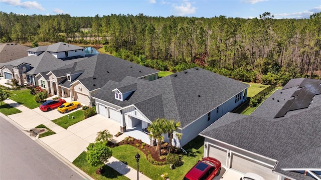 drone / aerial view with a residential view and a view of trees