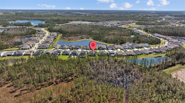 aerial view featuring a water view, a residential view, and a wooded view