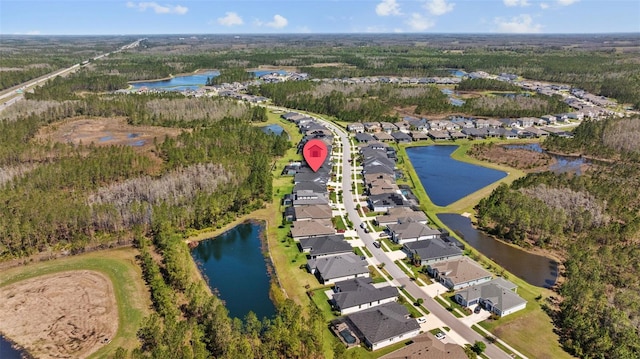 aerial view featuring a view of trees, a water view, and a residential view