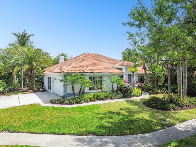 441 Village Dr, Tarpon Springs, FL 34689 - mediterranean / spanish-style house featuring an attached garage, a tiled roof, a chimney, and a front yard