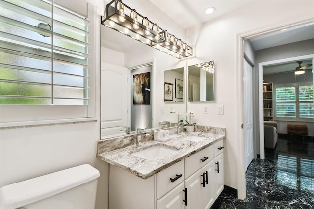 441 Village Dr, Tarpon Springs, FL 34689 - bathroom with marble finish floors, toilet, double vanity, baseboards, and recessed lighting