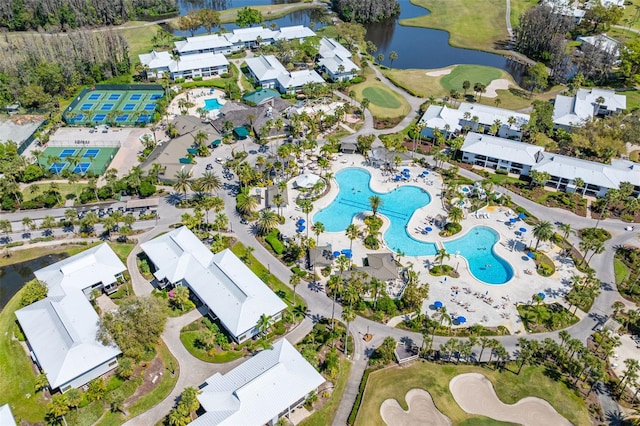 drone / aerial view featuring golf course view and a water view