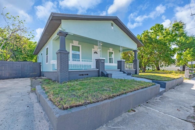 3101 N 15th St, Tampa, FL 33605 - view of front of house with stucco siding, a front lawn, fence, covered porch, and crawl space