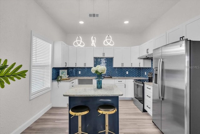3101 N 15th St, Tampa, FL 33605 - kitchen featuring visible vents, a kitchen island, stainless steel appliances, decorative backsplash, and under cabinet range hood