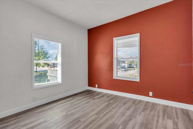 3101 N 15th St, Tampa, FL 33605 - empty room with a textured ceiling, baseboards, and wood finished floors