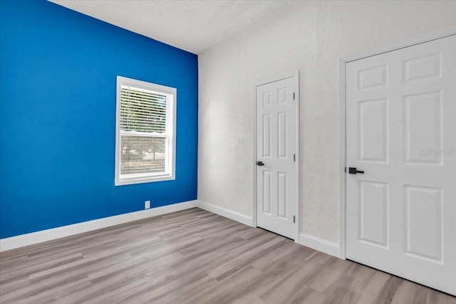 3101 N 15th St, Tampa, FL 33605 - unfurnished bedroom with wood finished floors, baseboards, a textured wall, and a textured ceiling