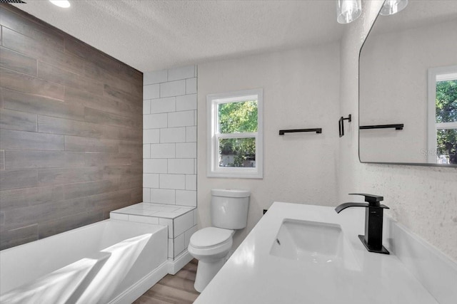 3101 N 15th St, Tampa, FL 33605 - full bathroom with toilet, wood finished floors, a wealth of natural light, and a textured ceiling