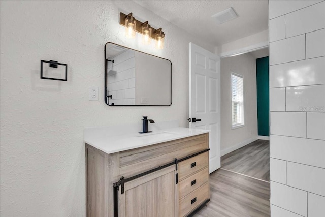 3101 N 15th St, Tampa, FL 33605 - full bathroom with a textured ceiling, wood finished floors, vanity, and a textured wall