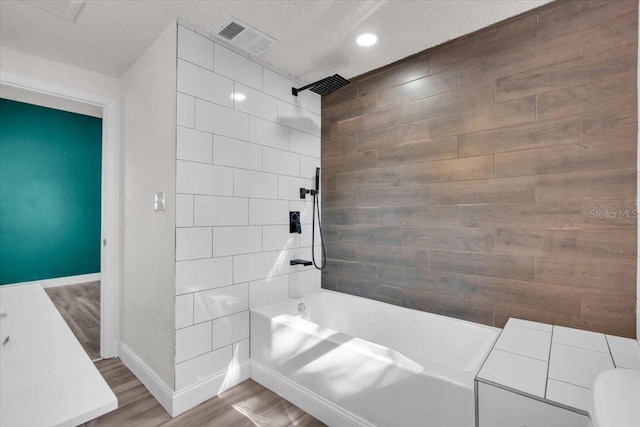 3101 N 15th St, Tampa, FL 33605 - full bath featuring visible vents, baseboards, shower / bathing tub combination, wood finished floors, and a textured ceiling
