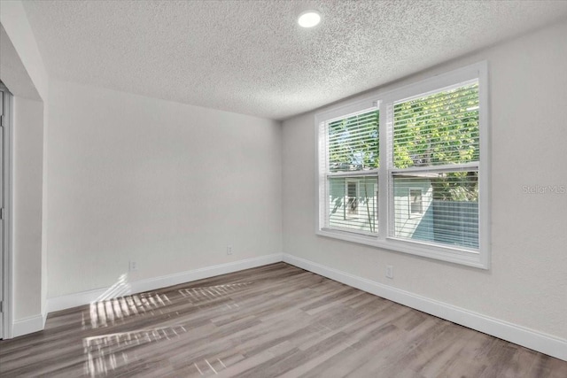 3101 N 15th St, Tampa, FL 33605 - spare room with baseboards, a textured ceiling, and wood finished floors