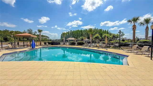 community pool featuring fence and a patio area