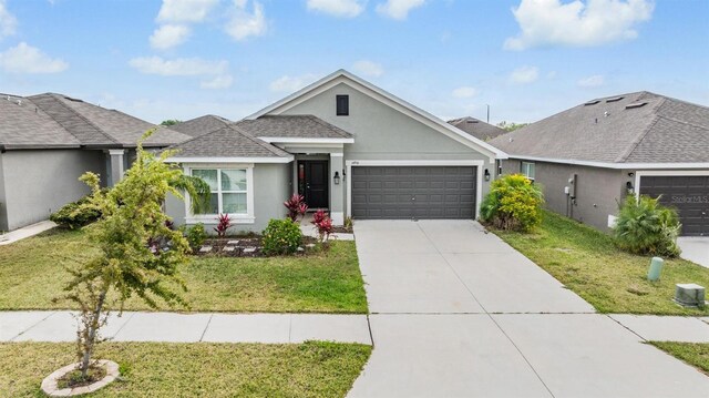 view of front of property featuring stucco siding, an attached garage, concrete driveway, and a front lawn