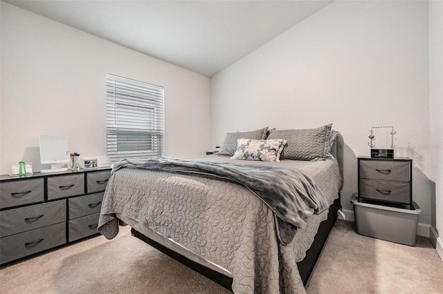 bedroom with light carpet and lofted ceiling