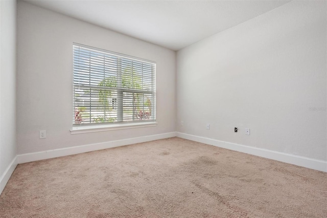unfurnished room with carpet and baseboards