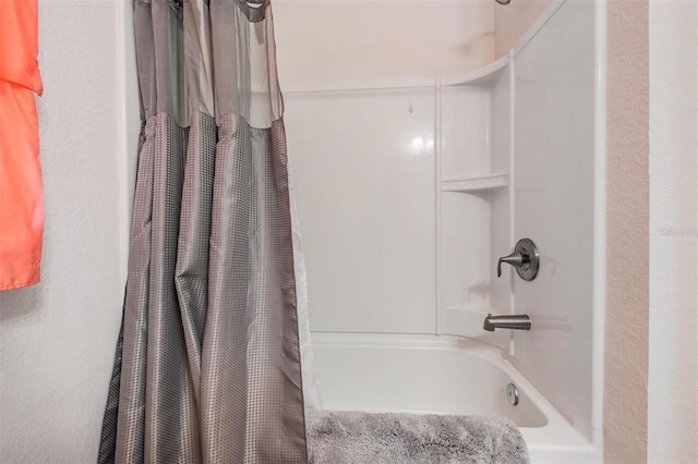 full bathroom with shower / bath combo and a textured wall
