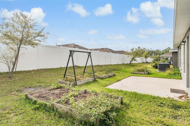 view of yard featuring a patio, a garden, a fenced backyard, and central AC