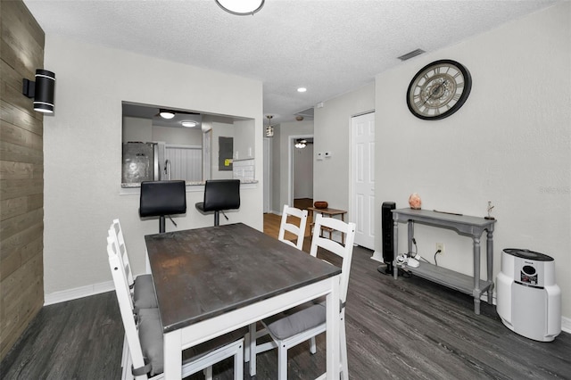 dining area with wood finished floors, visible vents, and a textured ceiling