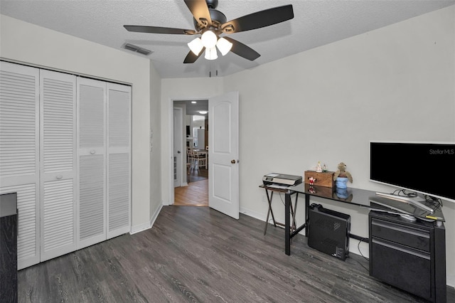 home office featuring visible vents, baseboards, ceiling fan, wood finished floors, and a textured ceiling