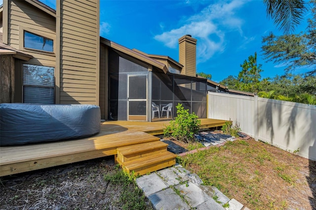 view of yard with fence, a deck, and a sunroom