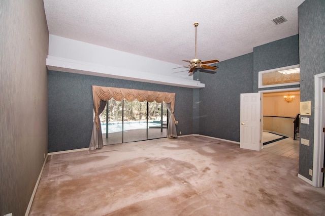 carpeted spare room with visible vents, a textured ceiling, baseboards, and ceiling fan