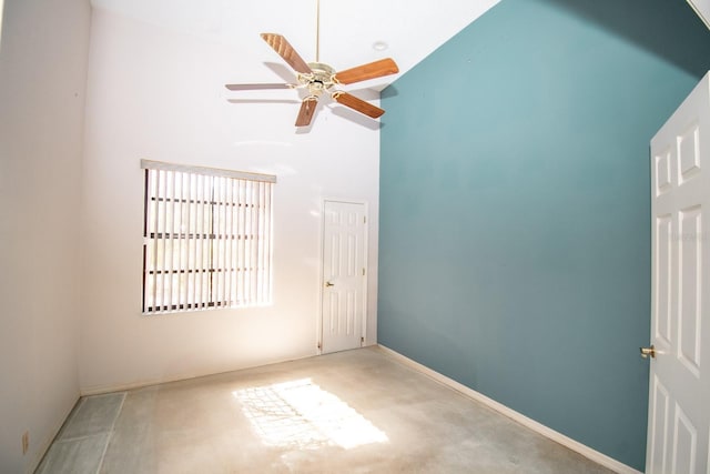 empty room with a ceiling fan and high vaulted ceiling
