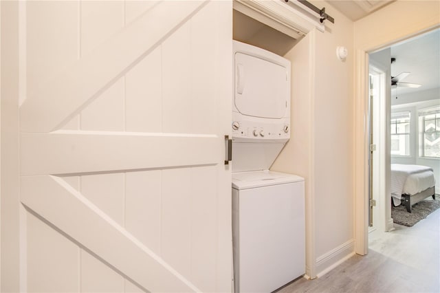 506 S Willow Ave Unit 7, Tampa, FL 33606 - laundry area featuring baseboards, laundry area, stacked washing maching and dryer, and light wood-style floors