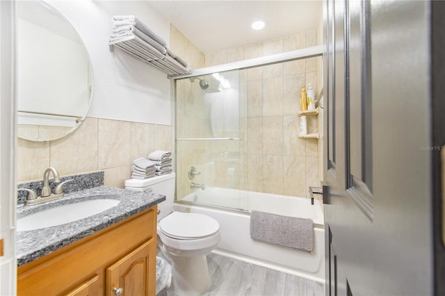506 S Willow Ave Unit 7, Tampa, FL 33606 - bathroom featuring toilet, wood finished floors, combined bath / shower with glass door, tile walls, and vanity