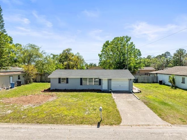 ranch-style home featuring a front yard, an attached garage, and driveway