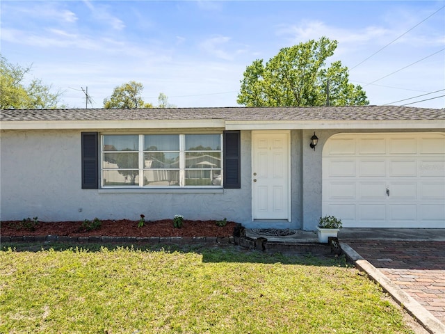 single story home featuring stucco siding, decorative driveway, an attached garage, and a front lawn