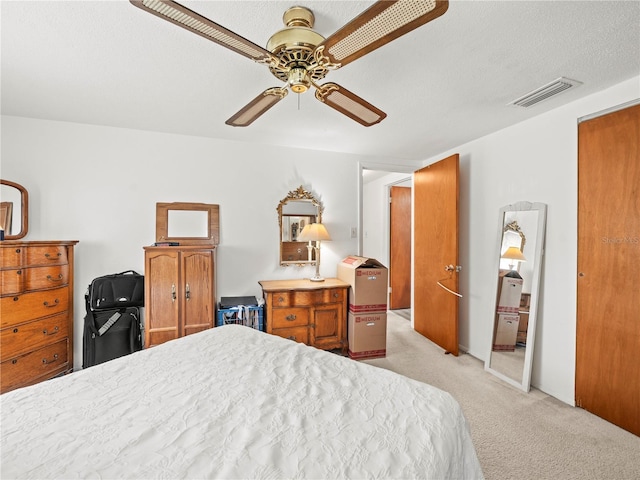 bedroom with light colored carpet, a ceiling fan, and visible vents