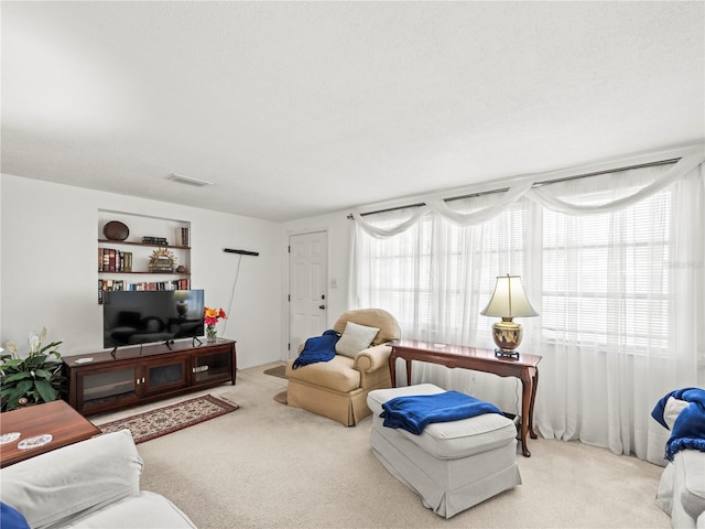 living room featuring carpet flooring, visible vents, and plenty of natural light