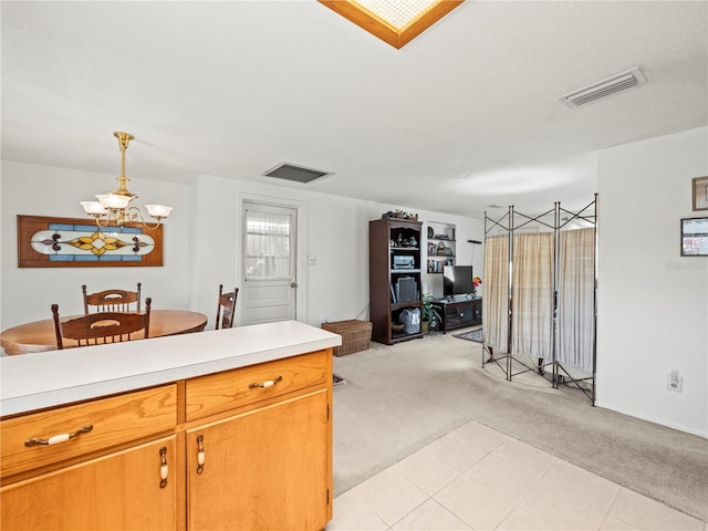 kitchen with open floor plan, visible vents, a notable chandelier, light colored carpet, and light countertops
