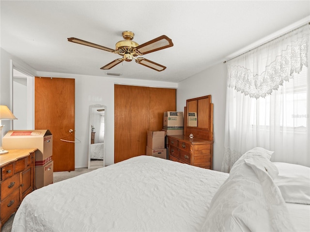 carpeted bedroom with visible vents and a ceiling fan