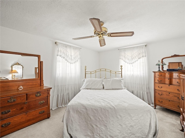 bedroom with a ceiling fan and light colored carpet