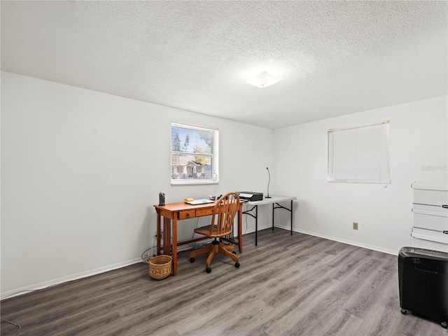 home office featuring baseboards, wood finished floors, and a textured ceiling