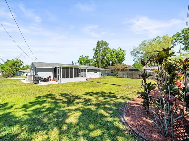 view of yard featuring a patio area, a sunroom, and fence