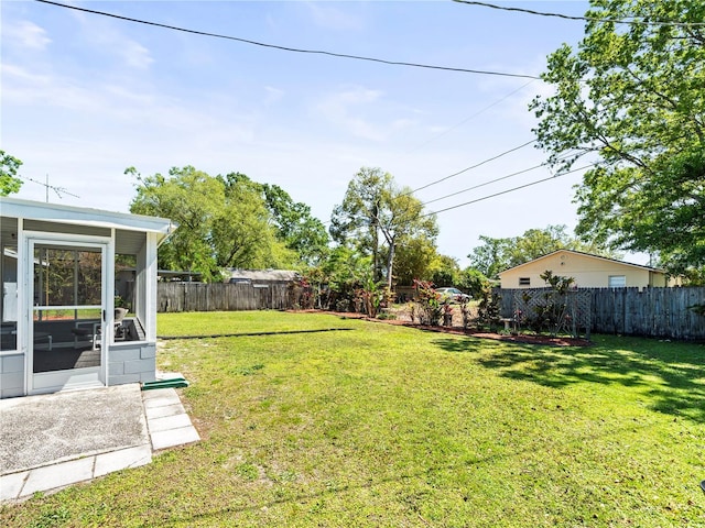 view of yard with a fenced backyard and a sunroom