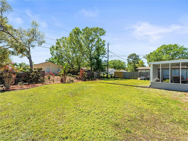 view of yard with a fenced backyard and a sunroom