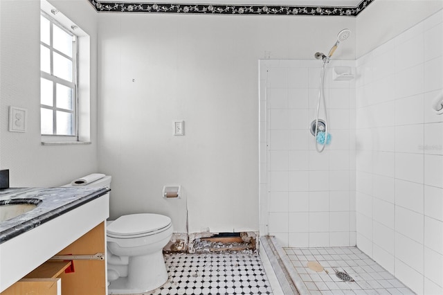 bathroom featuring tiled shower, toilet, and vanity